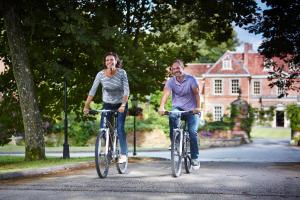 a man and a woman riding bikes down a street at Lainston House in Winchester