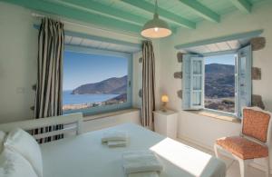 a room with a table and a large window at Theologos Houses in Grikos