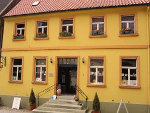a yellow house with windows and stairs in front at Im kurfürstlichen Zollamt in Tangermünde