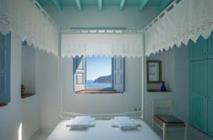 a bedroom with a window and a bed with towels at Theologos Houses in Grikos