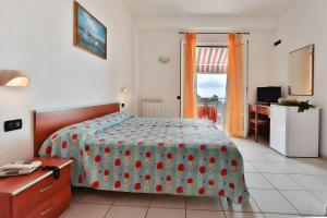 ein Schlafzimmer mit einem Bett, einem Schreibtisch und einem Fenster in der Unterkunft Hotel Villa Rita in Ischia