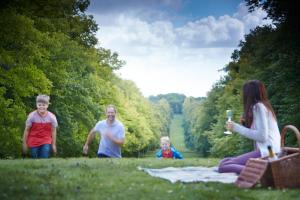 a group of people sitting on a blanket in the grass at Lainston House in Winchester