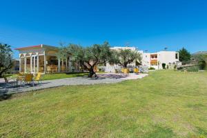 una casa con un patio con sillas y un árbol en Hidden Garden, en Afantou