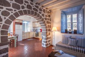 a kitchen and a living room with a stone archway at Theologos Houses in Grikos