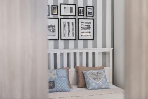 a room with a crib with pillows and framed pictures at Apartments Jelavić in Sutomišćica