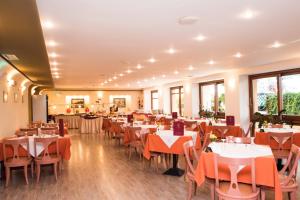 a dining room with tables and chairs and windows at Hotel Brascos in Rethymno