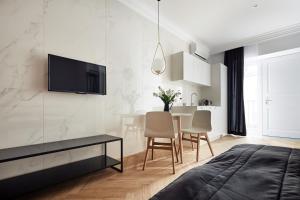 ein Schlafzimmer mit einem Tisch und einem TV an der Wand in der Unterkunft St Agnes Apartments Old Town in Krakau