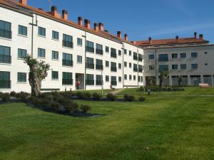 a large white building with a green lawn in front of it at Apartamento Agarimo - La tranquilidad de una isla de menos de 5000 habitantes in Isla de Arosa