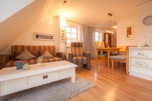 ein Wohnzimmer mit einem Sofa und einem Tisch in der Unterkunft Haus Anke, Wohnung Muschelsucher, Westerlandstr. 37 in Wenningstedt-Braderup