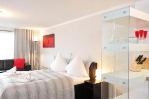 ein Hotelzimmer mit einem Bett und einer Glaswand in der Unterkunft Sylter Mitte in Westerland