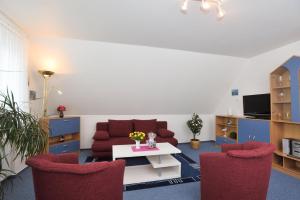 ein Wohnzimmer mit einem Sofa, einem Tisch und Stühlen in der Unterkunft Wohnung Sylthome in Westerland