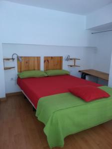 1 dormitorio con 1 cama grande con sábanas rojas y verdes en Costanerja, en Nerja