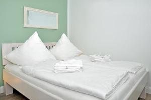 ヴェスターラントにあるSylter-Bernsteinの白いベッド(白い枕、タオル付)