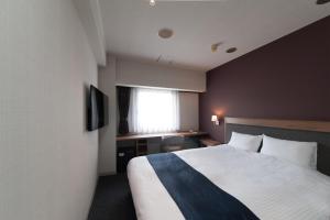 ein Hotelzimmer mit einem Bett und einem Fenster in der Unterkunft The Grand Court Tsu Nishi in Tsu