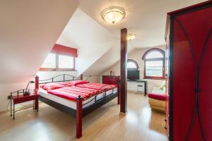um quarto com uma cama vermelha num sótão em Farma Loreta em Vlasim