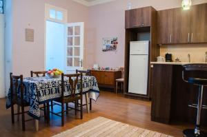 a kitchen with a table with chairs and a refrigerator at Guest House Lile in Tbilisi City