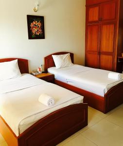 two beds in a hotel room with two beds sidx sidx sidx at Panchan Place in Ubon Ratchathani
