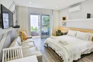 a bedroom with a bed and a couch at Laanhof Studios in Stellenbosch