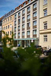 un gran edificio con coches estacionados frente a él en Hotel Concorde en Múnich