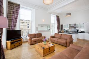 a living room with two couches and a tv at Blythswood Square Apartments in Glasgow