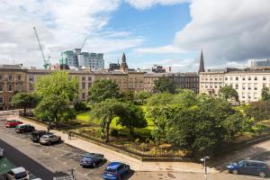 a city skyline with cars parked in a parking lot at Blythswood Square Apartments in Glasgow