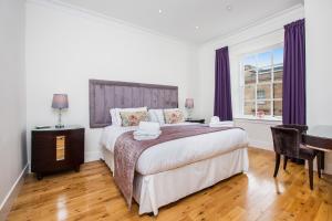 Ένα ή περισσότερα κρεβάτια σε δωμάτιο στο Blythswood Square Apartments