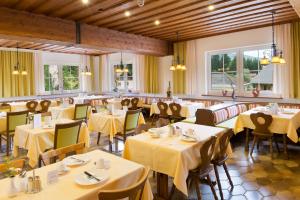 ein Restaurant mit Tischen und Stühlen mit gelbem Tischtuch in der Unterkunft Der Seebacherhof in Tauplitz