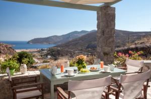 a table on a patio with a view of the ocean at Theologos Houses in Grikos
