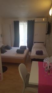 a small room with two beds and a table at Studio Andric in Drvenik +12 photos