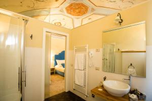 W łazience znajduje się umywalka i lustro. w obiekcie Palazzo Franceschini w mieście Cascia