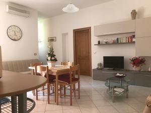 salon ze stołem, krzesłami i zegarem w obiekcie Casa Rosada Alghero w mieście Alghero