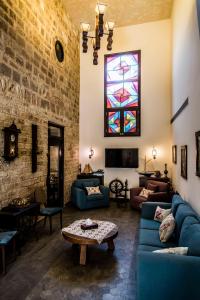 a living room with blue couches and a stained glass window at Asamina Boutique Hotel in So&ucirc;r