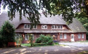 a large red brick house with a roof at Ferienwohnungen Wulfshof in Schneverdingen