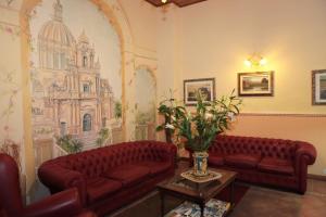 a living room filled with furniture and flowers at Hotel Il Barocco in Ragusa