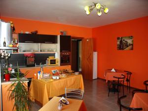 a kitchen with orange walls and tables and chairs at B&B Sant'Eufemia in Lamezia Terme