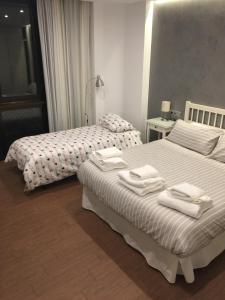 two beds in a hotel room with towels on them at Boulevard Suite Cordoba in Córdoba