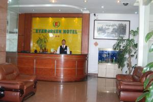 a man is sitting at a bar in a lobby at Evergreen Hotel in Antananarivo