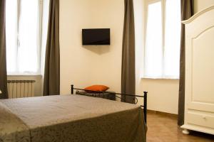a bedroom with a bed and a tv on the wall at B&B Domus Piazza del Popolo in Rome