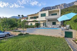 a house with a yard with a swimming pool at Vila Dunja in Makarska