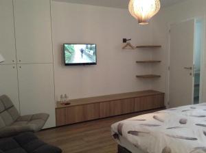 a bedroom with a bed and a television on the wall at Pluimpapaver Hotel & Glamping in Aarschot