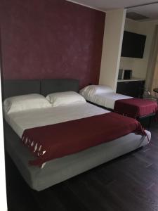 2 Betten in einem Zimmer mit roten Wänden in der Unterkunft Joia Hotel & Luxury Apartments in Brusaporto