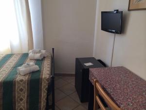 um quarto com duas camas e uma mesa e uma televisão em Hotel Le 3 Fonti em Loro Ciuffenna