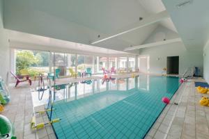 een groot zwembad in een groot gebouw bij Villa Kempen-Broek in Weert