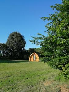 un pequeño edificio de madera en un campo con árboles en Cosy Camping Suffolk en Ipswich
