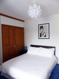 a bedroom with a white bed and a chandelier at 3 Luxury En-suite Bedrooms in Cardiff