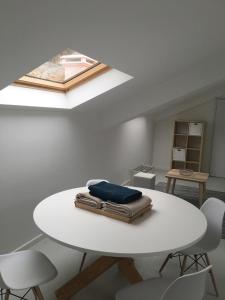 サン・マルティーニョ・ド・ポルトにあるSerene Waterfront Apartmentの白いテーブル、椅子、天窓が備わる客室です。