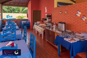ein Restaurant mit blauen Tischen und blauen Stühlen in der Unterkunft Pousada Lua de Tomate in Porto Seguro