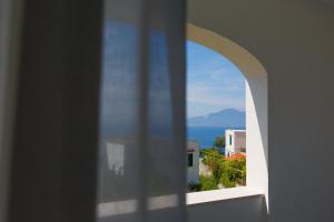 een uitzicht op de oceaan vanuit een raam van een gebouw bij Santa Maria Vecchia Relais in Vico Equense