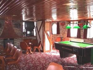 a room with a pool table in a room with chairs at The Poldark Inn in Delabole