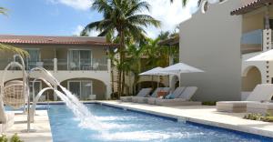 a swimming pool with a fountain in front of a house at Catalonia Royal La Romana Adults Only - All Inclusive in Bayahibe
